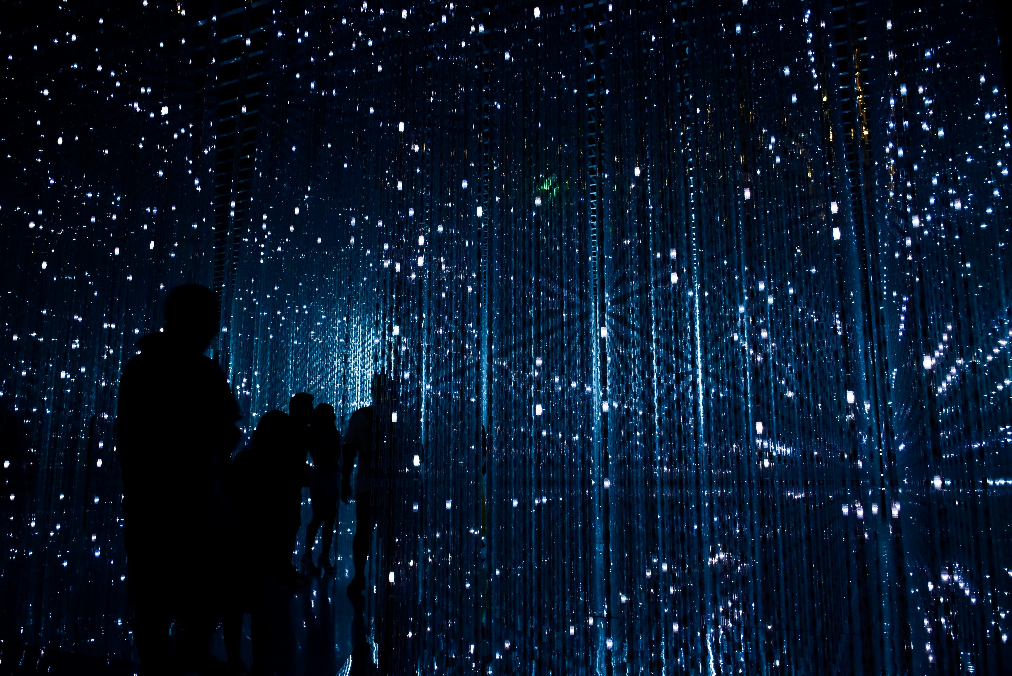 Tiny pin pricks of lights, some in lines, dark silhouetes
